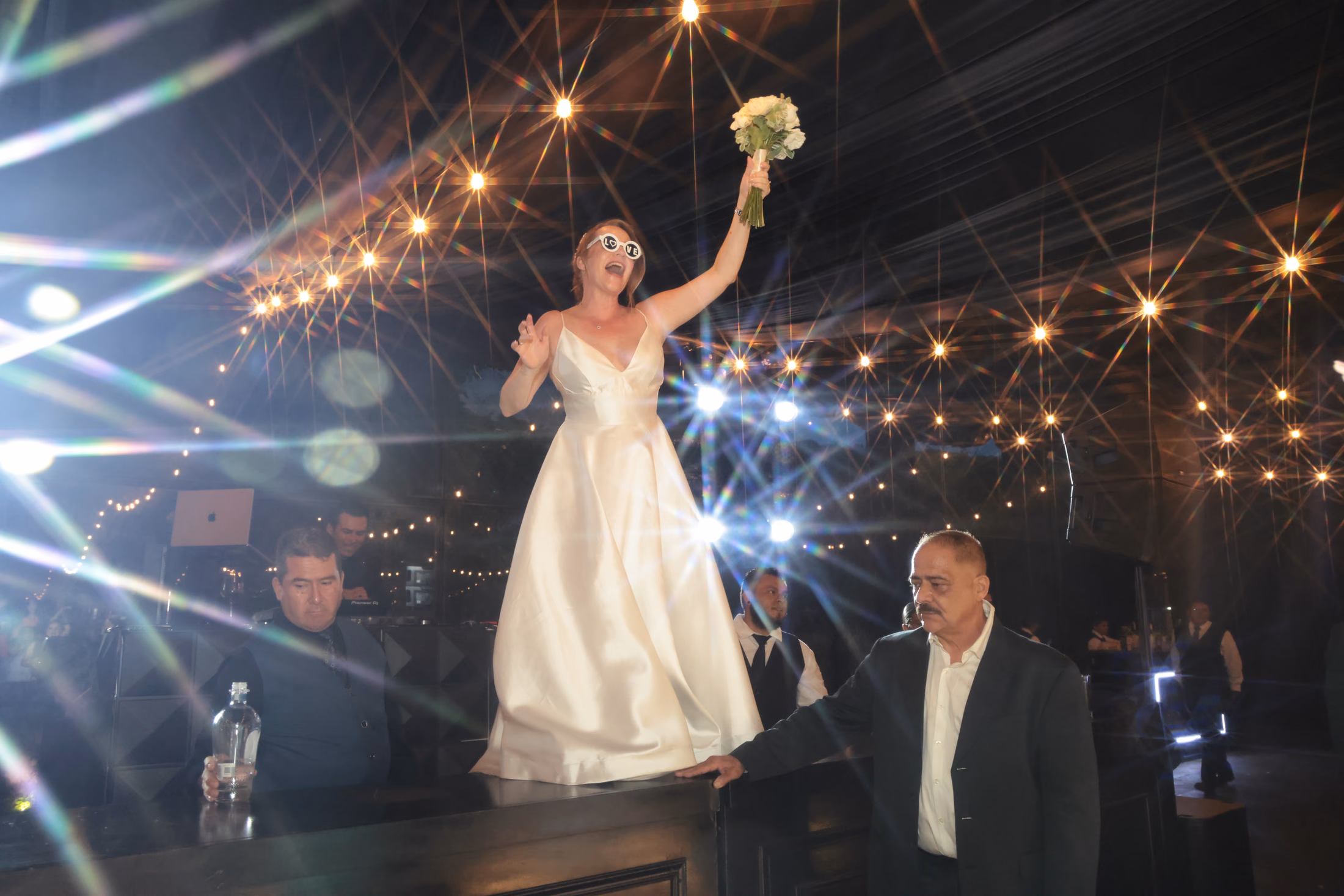 Novia celebrando sobre una mesa durante la fiesta